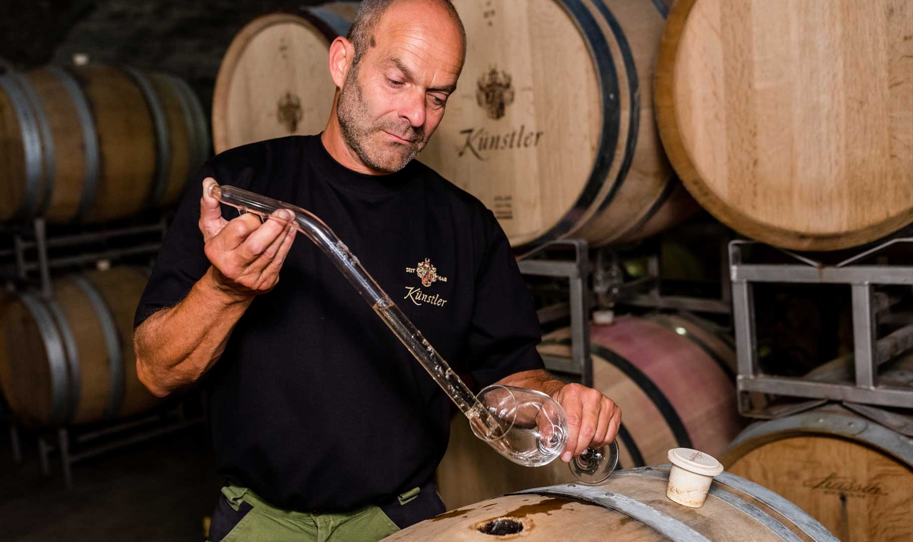 Kellermeister Rolf Schregel entnimmt eine Weinprobe aus dem Barrique (Axel Gross Fotografie) Kellermeister Rolf Schregel entnimmt eine Weinprobe aus dem Barrique